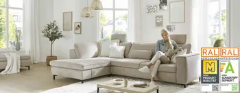 Frau sitzt auf bequemen Sofa und liest Zeitschrift